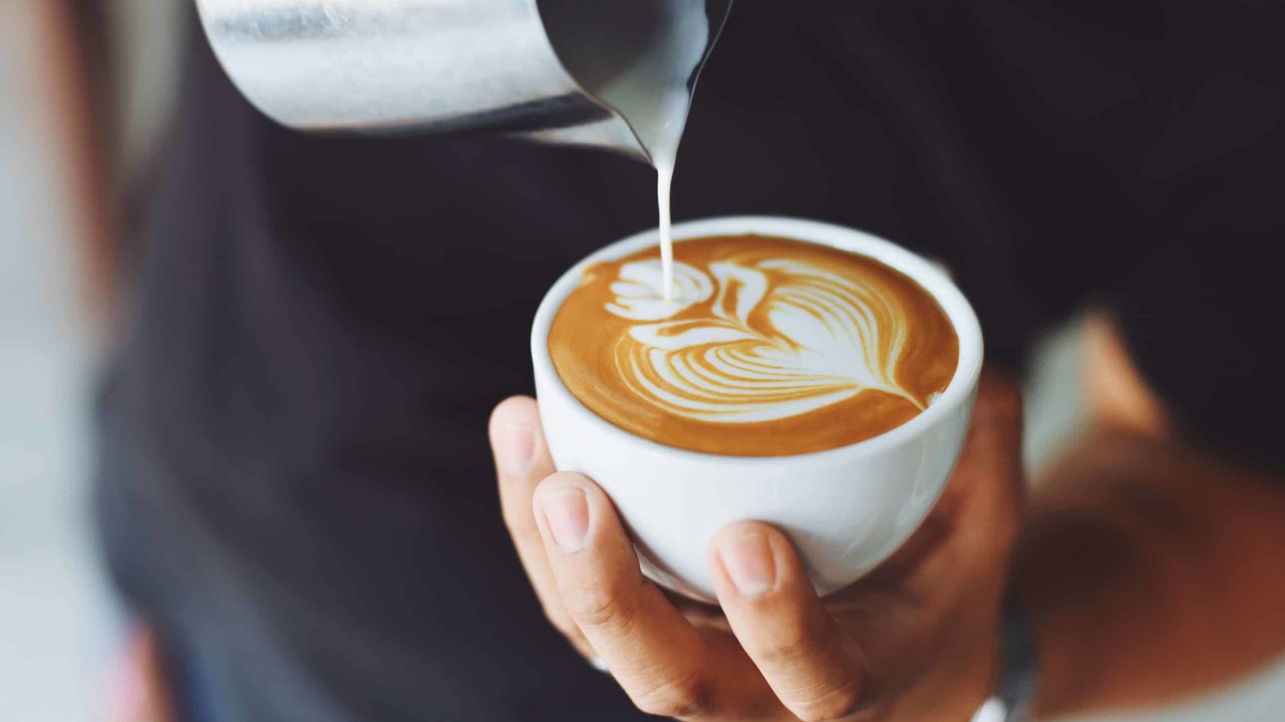 tasse de café avec du lait versé en forme de coeur